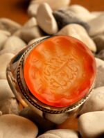 انگشتر عقیق یمنی پرتقالی خطی کهنه قاجاری ذکر صلوات در وسط و 12امام در دور با پایه فدیوم